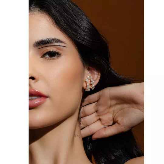Detalhe das pérolas aplicadas no ear cuff dourado