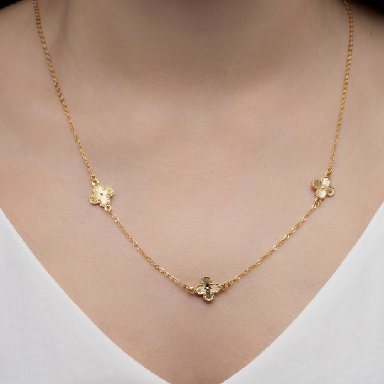 Detalhe dos trevos delicados em banho de ouro 18k do colar longo