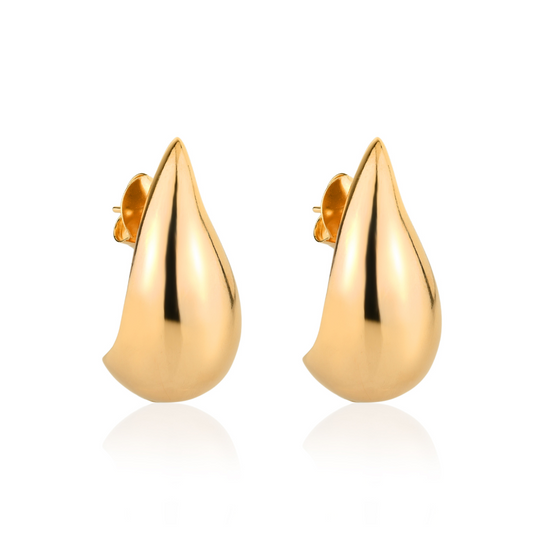 Mulher usando brinco gota trend dourado em produção elegante