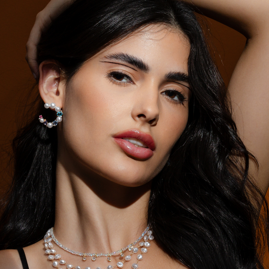 Mulher usando brinco pérolas banho ouro 18k em evento elegante