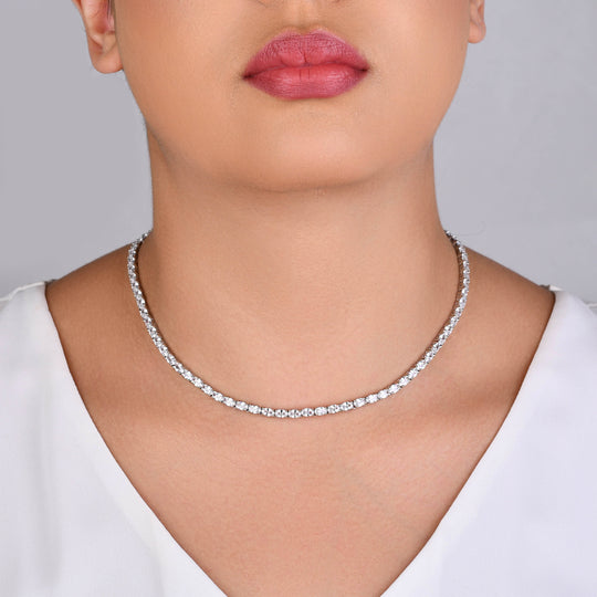 Mulher usando conjunto de brinco e colar prateado com zircônias cristal