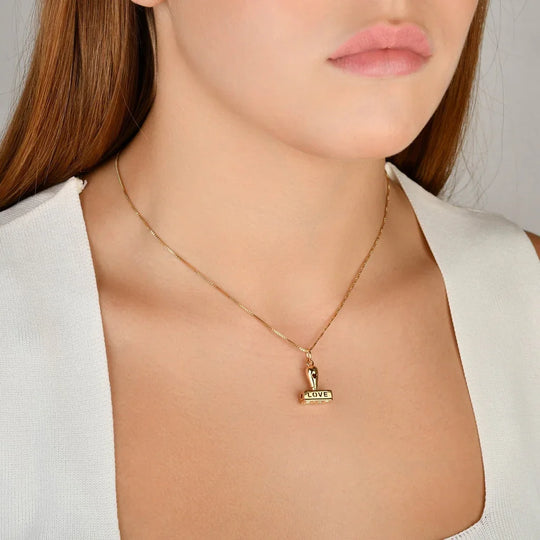 Colar Carimbo Love banho ouro 18k em destaque, plaquinha minimalista com a palavra Love