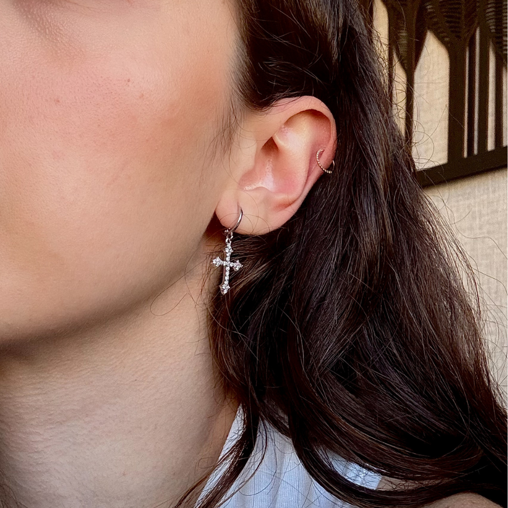 Detalhe da cravação de micro zircônias cristal no brinco cruz dourado