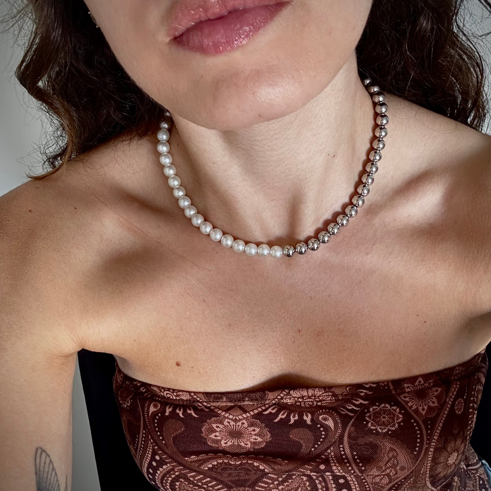 Modelo usando choker metade pérola banho ródio no pescoço, combinada com look moderno