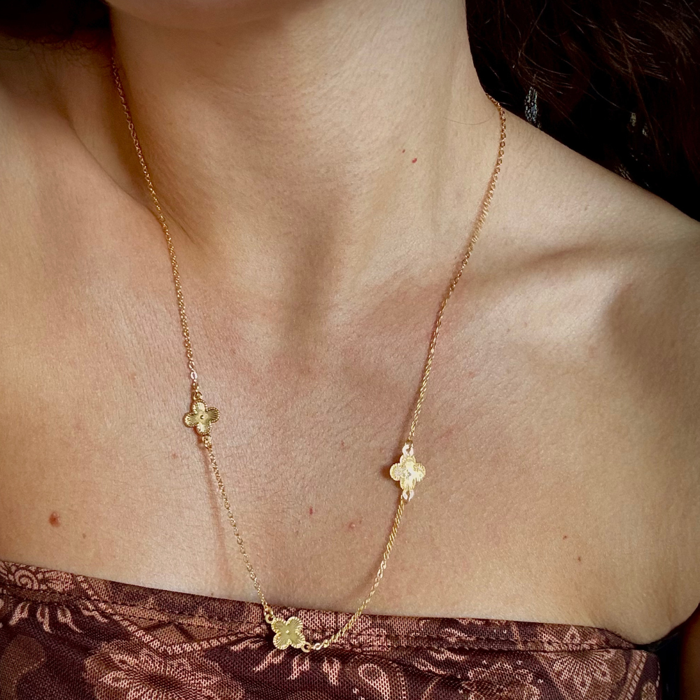 Modelo usando colar longo trevos dourado com extensor ajustável