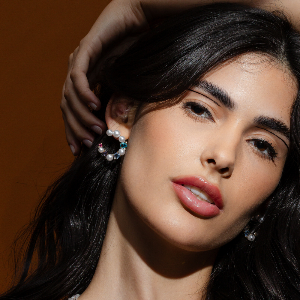 Mulher usando brinco pérolas banho ouro 18k em evento elegante