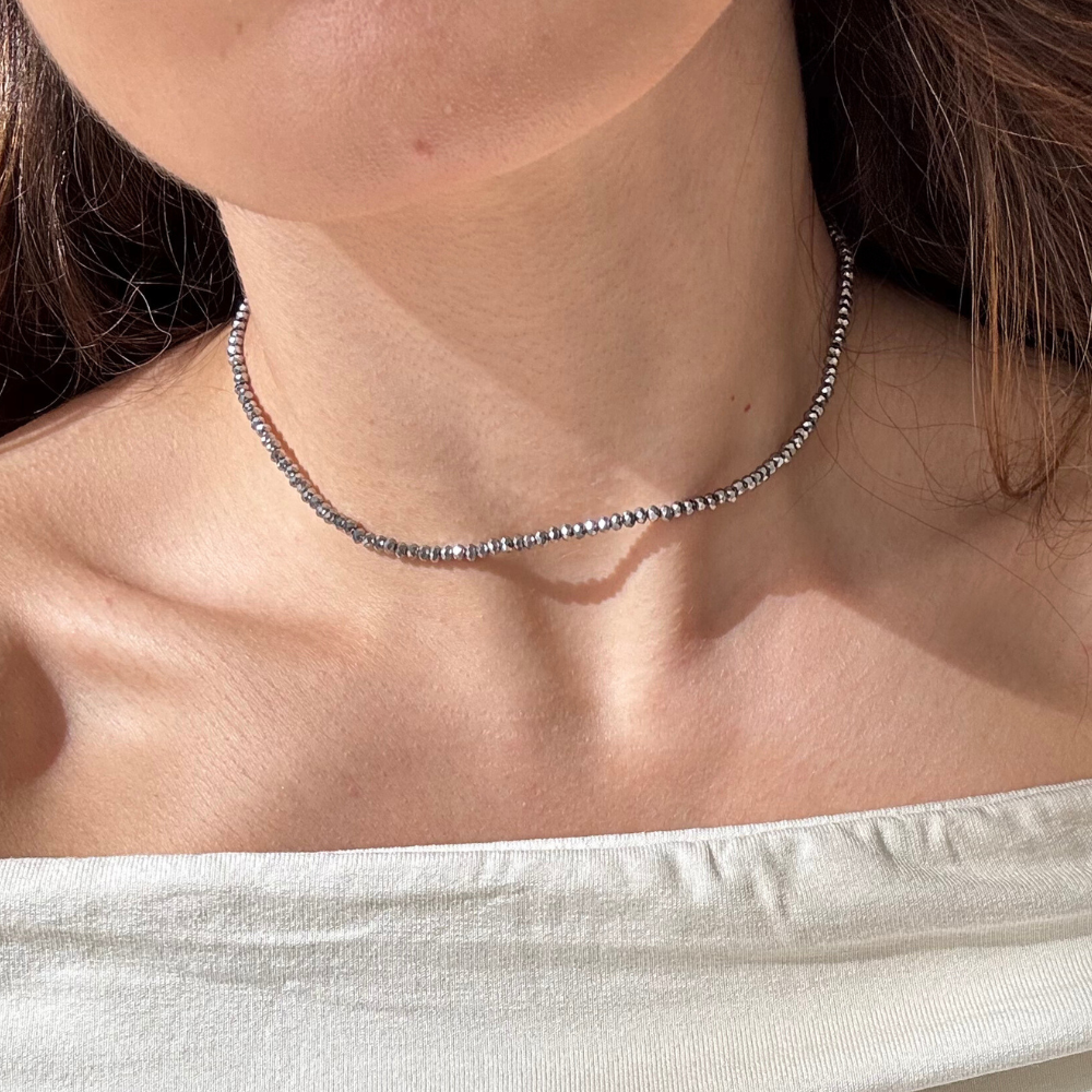 Mulher usando colar cristais prata com banho dourado no pescoço
