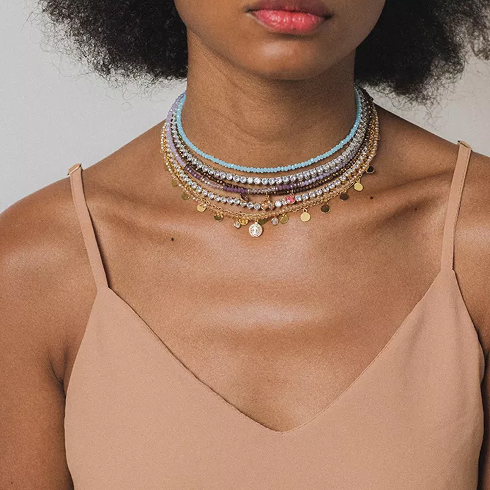 Modelo usando colar de cristais champagne dourado no pescoço em ocasião elegante