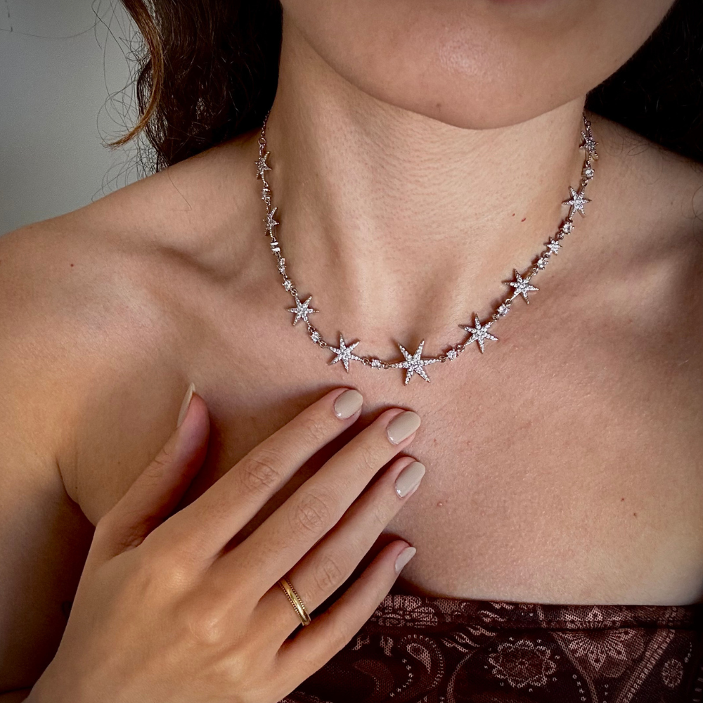 Mulher usando colar de estrelas dourado com decote elegante