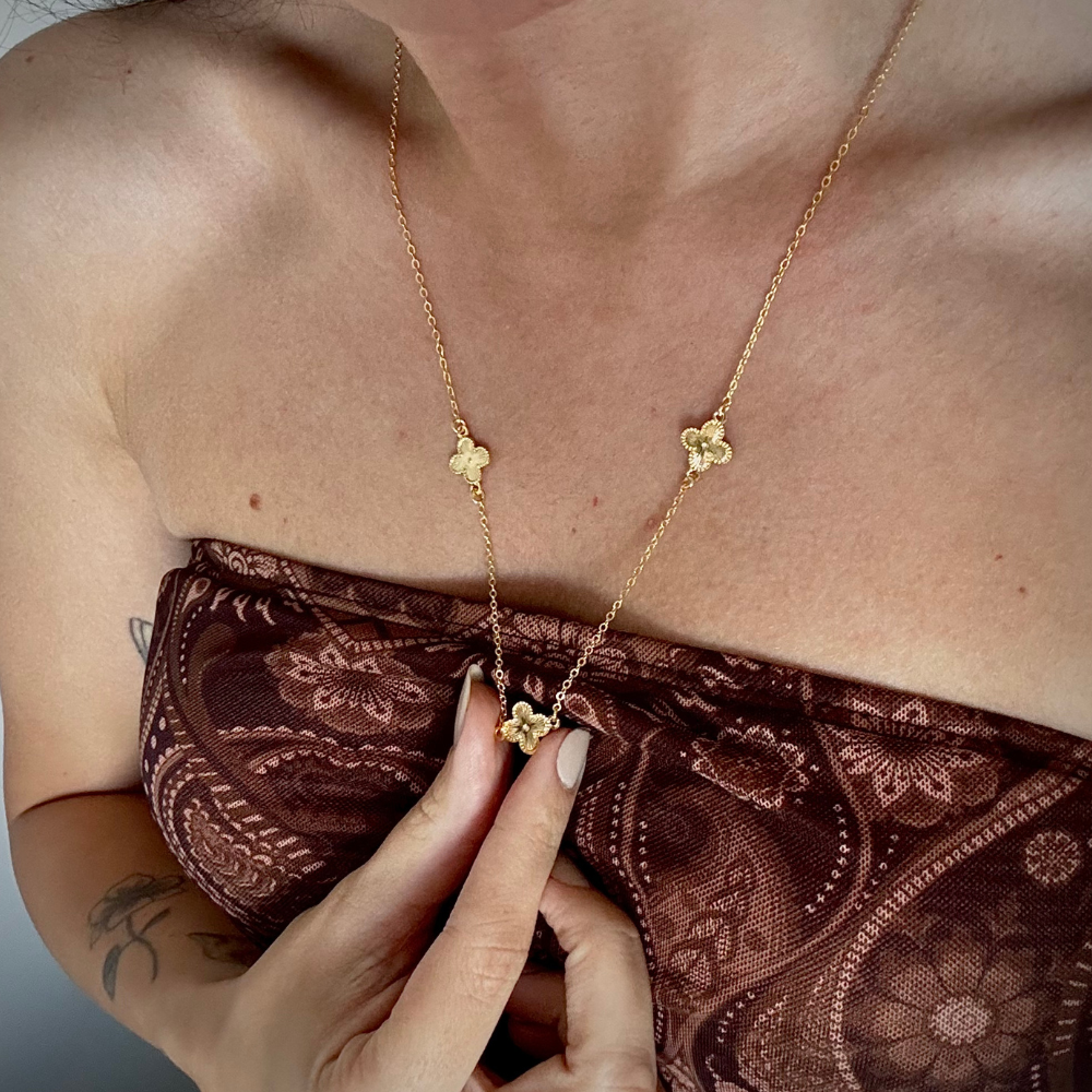 Modelo usando colar longo trevos dourado com extensor ajustável
