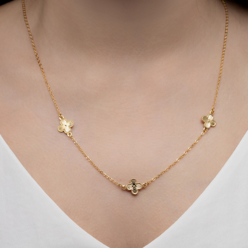 Detalhe dos trevos delicados em banho de ouro 18k do colar longo