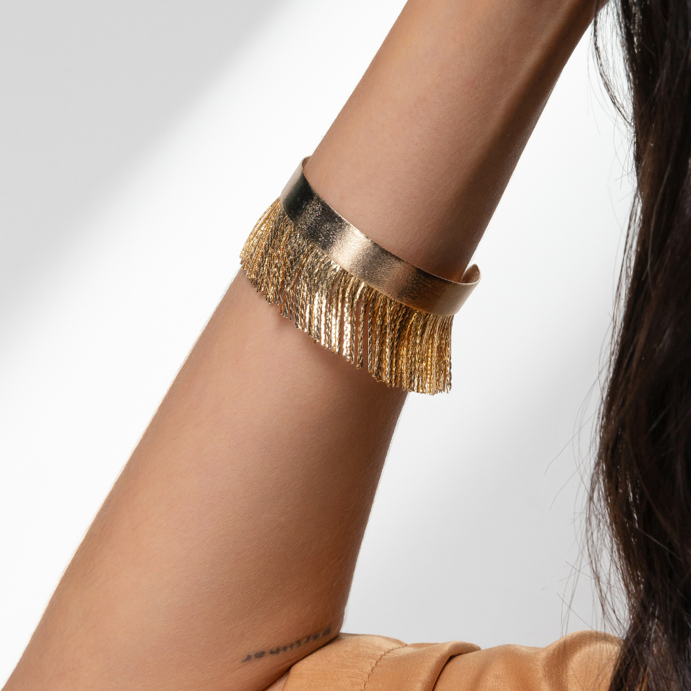 Mulher usando bracelete rígido franja no pulso com look moderno e elegante