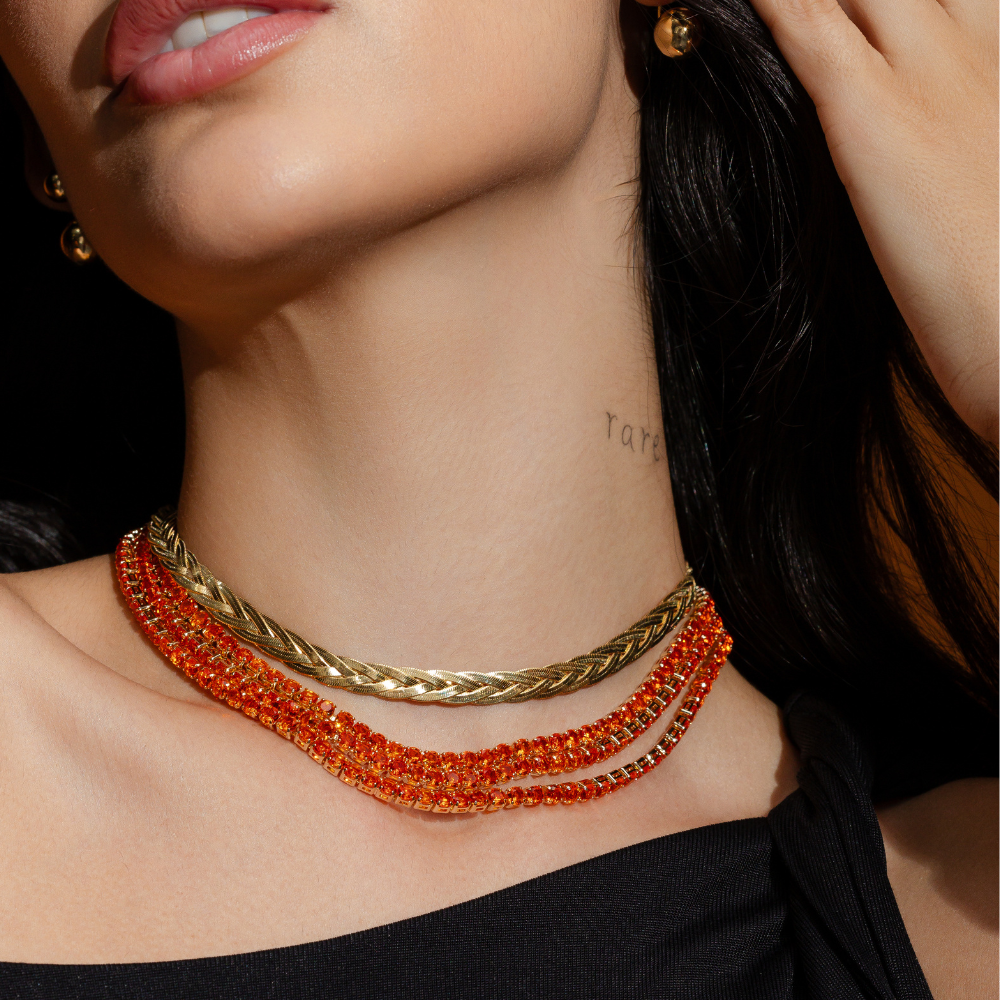 Mulher usando colar riviera laranja banho ouro 18k