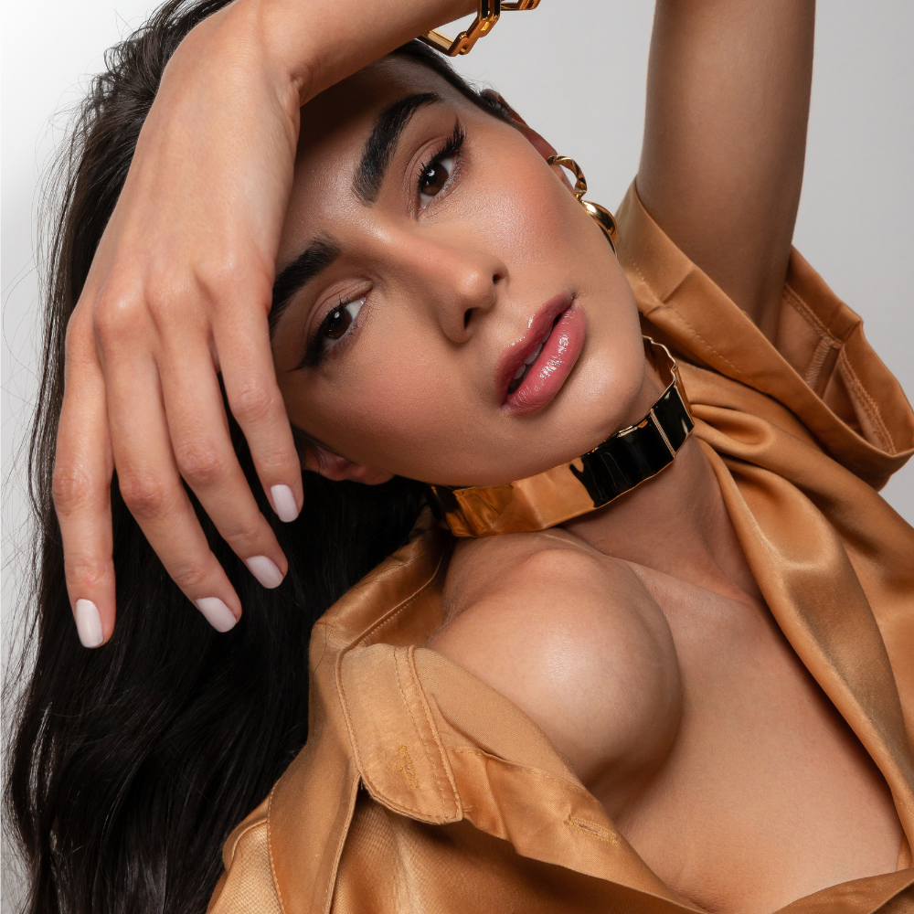 Mulher usando choker rígida martelada dourada com decote elegante