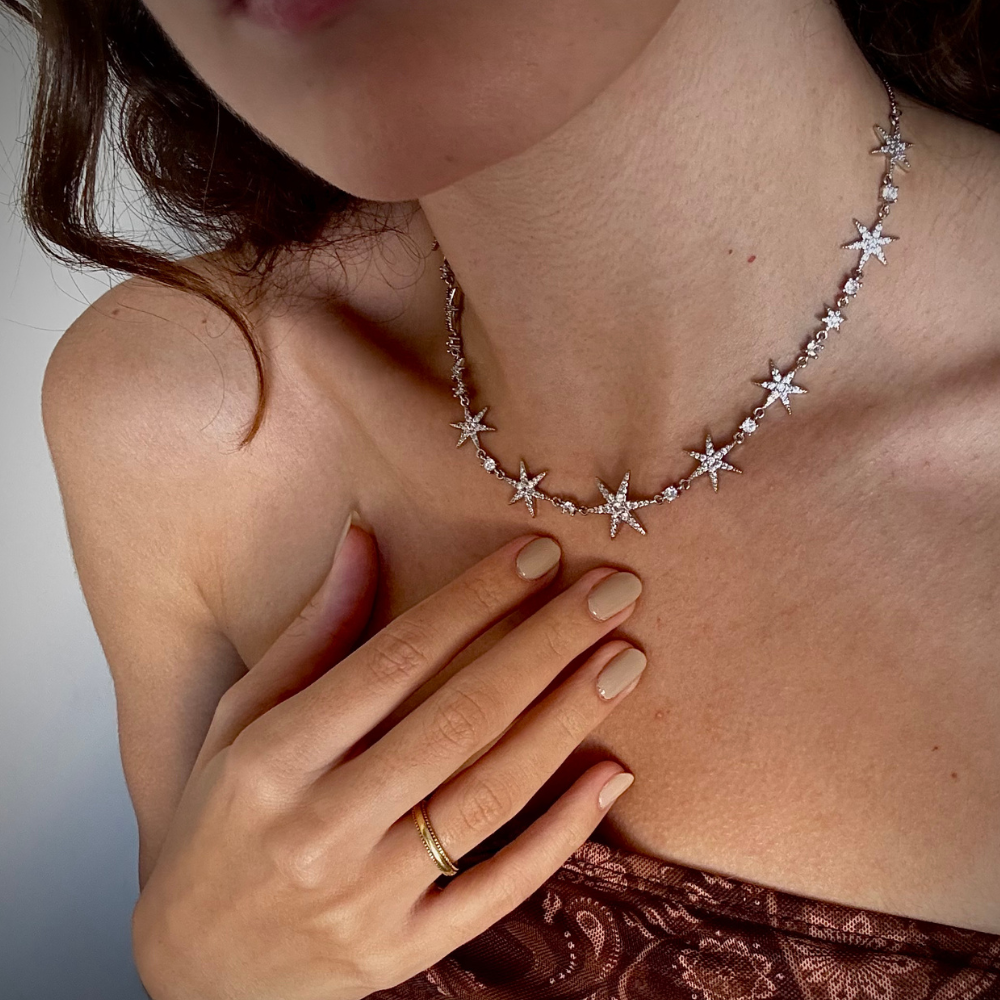 Mulher usando colar de estrelas dourado com decote elegante