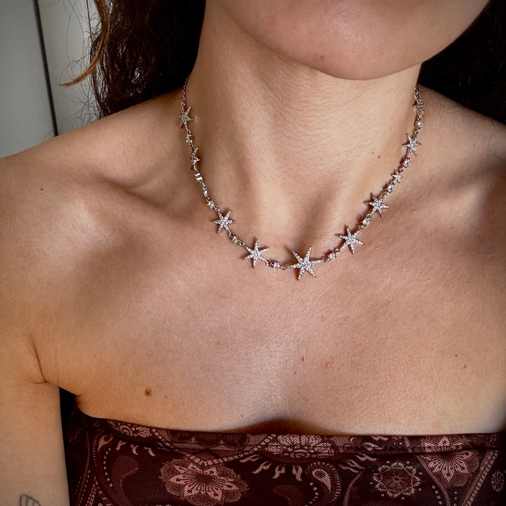 Mulher usando colar de estrelas dourado com decote elegante