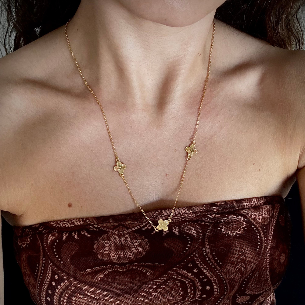 Modelo usando colar longo trevos dourado com extensor ajustável