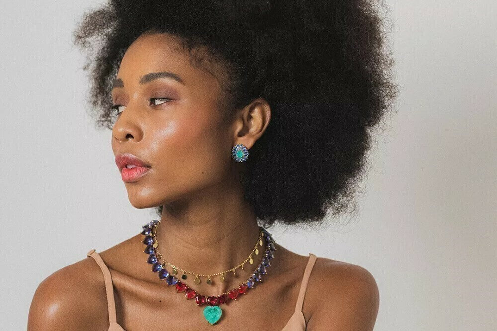 Mulher usando colar coração robusto dourado no pescoço em look casual
