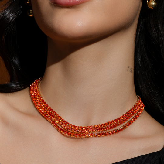 Mulher usando colar riviera laranja banho ouro 18k