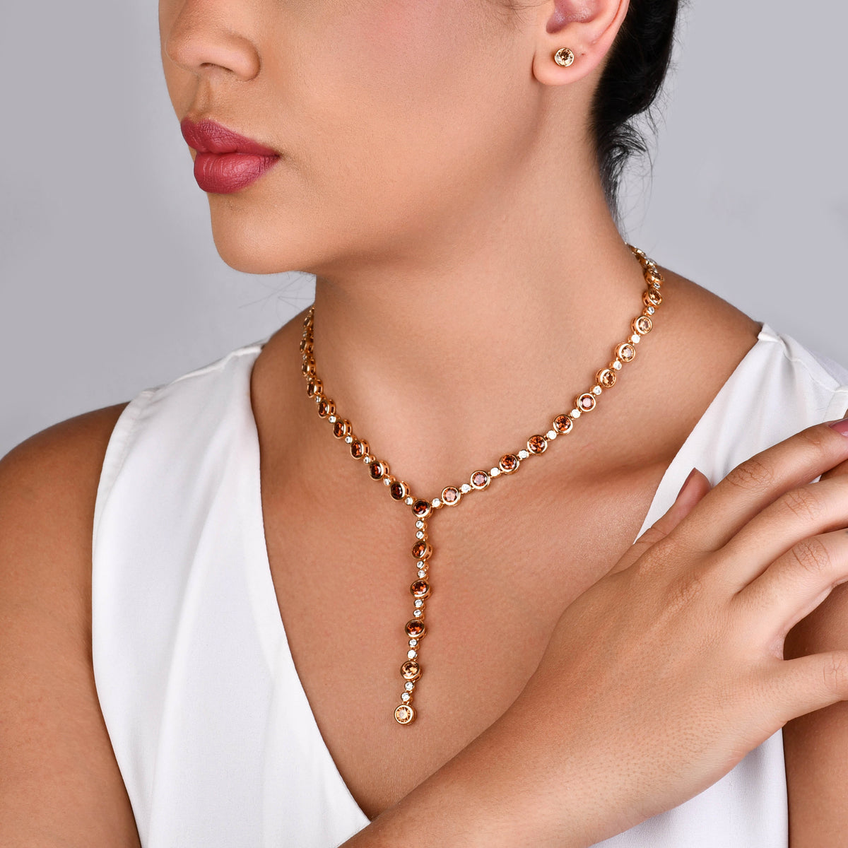 Conjunto brinco e colar com zircônias âmbar e banho ouro 18k sobre fundo claro