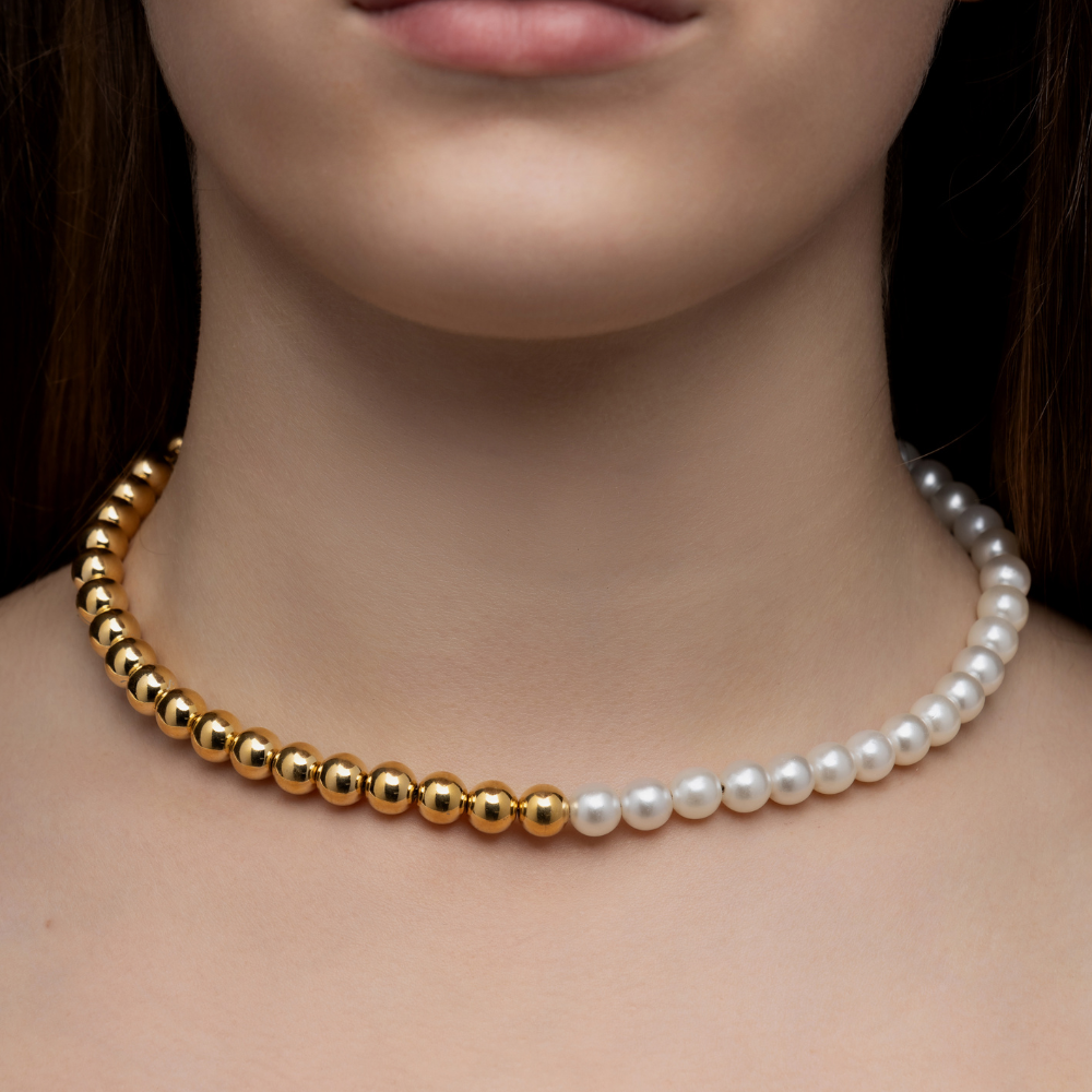 Detalhe do design da choker com metade em esferas douradas e metade em pérolas