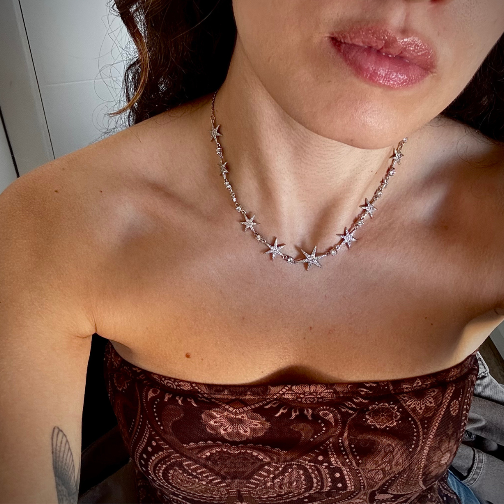 Mulher usando colar de estrelas dourado com decote elegante