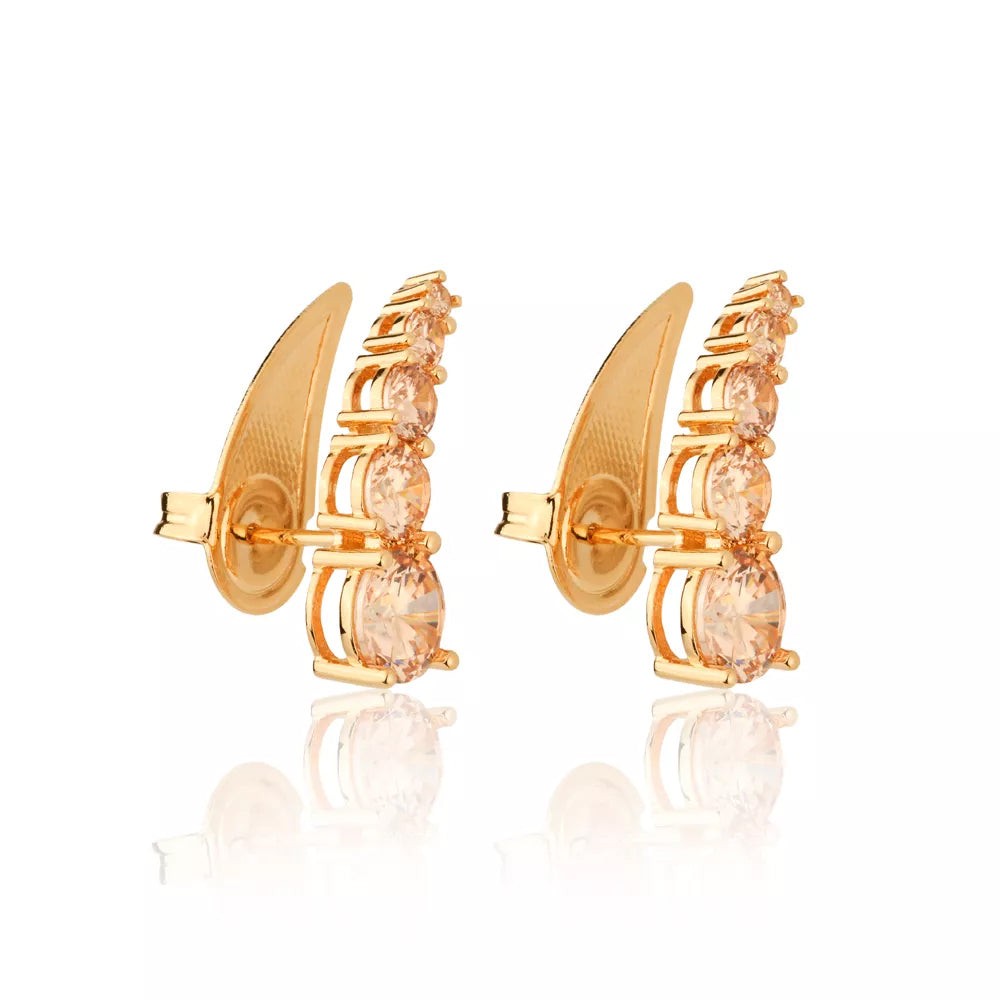 Detalhe das cinco zircônias champagne cravejadas no brinco dourado