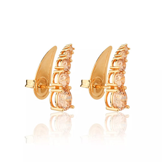 Detalhe das cinco zircônias champagne cravejadas no brinco dourado