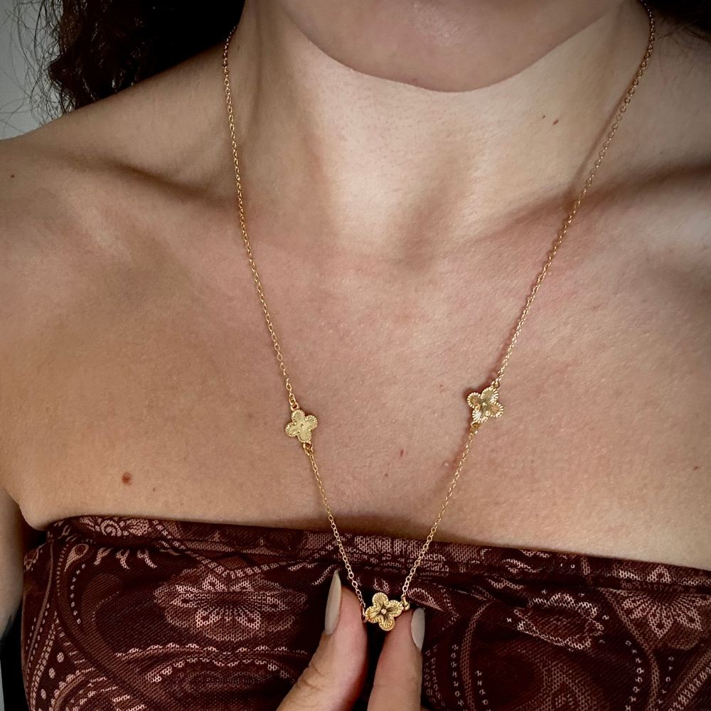 Modelo usando colar longo trevos dourado com extensor ajustável