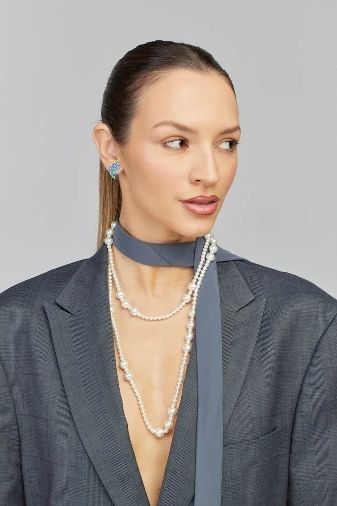 Colar de pérolas com pingente azul e blazer cinza, joia elegante e sofisticada para ocasiões especiais